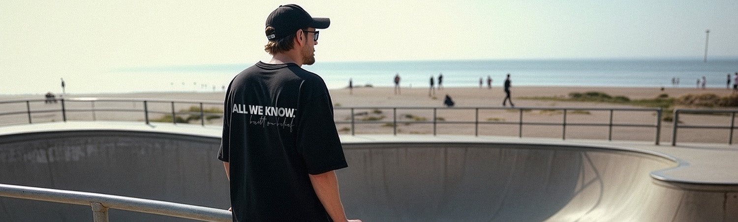 Man in oversized black t-shirt at skatepark showing simple streetwear outfit formula